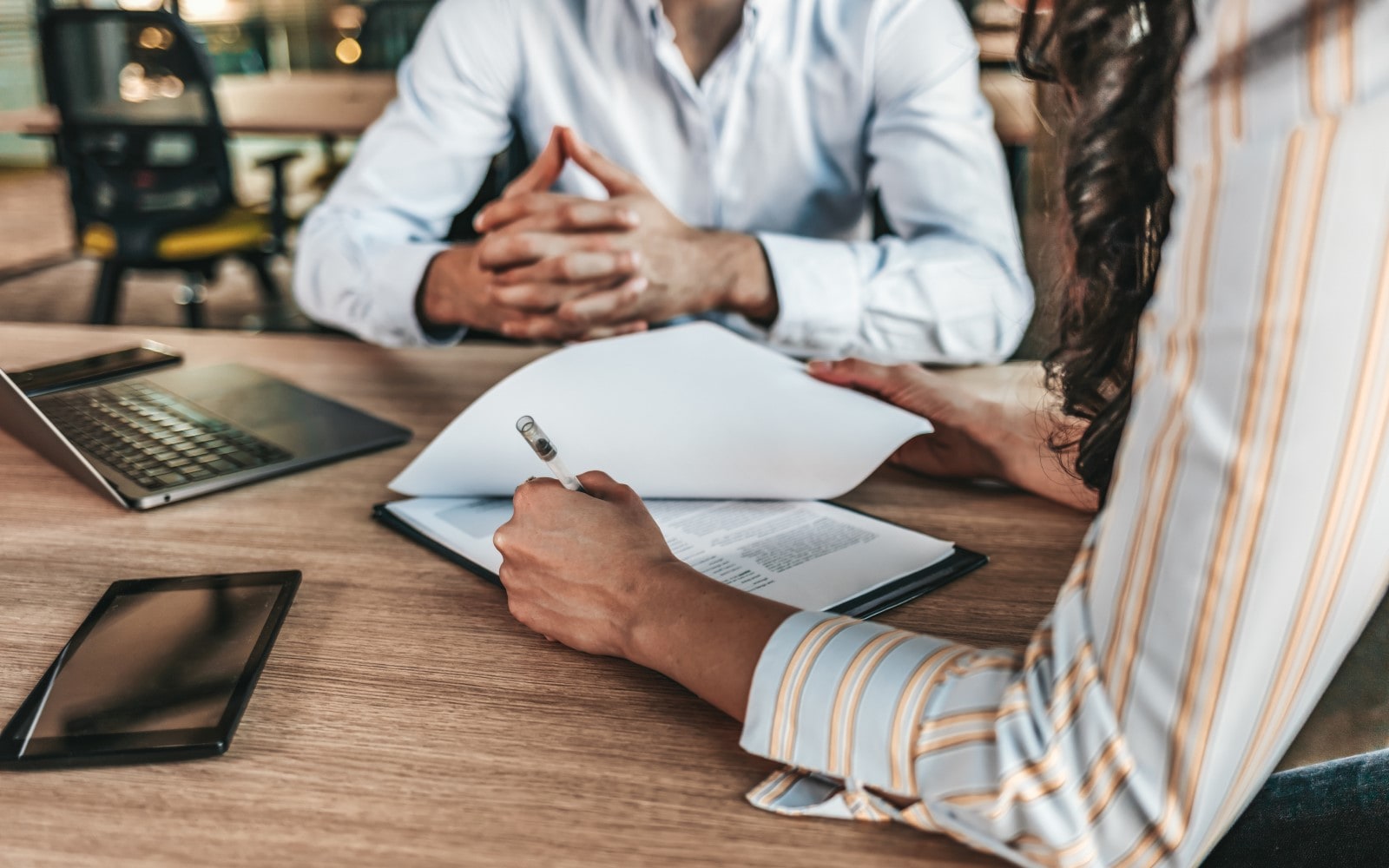 Two business professionals sitting at a table reviewing a contract