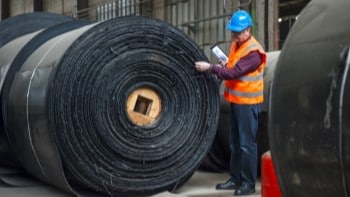 Warehouse worker with roll of industrial lining