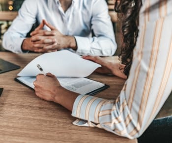 Two business professionals sitting at a table reviewing a contract