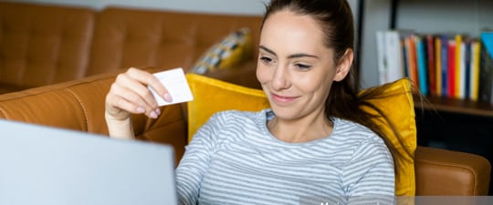 Happy woman shopping on couch