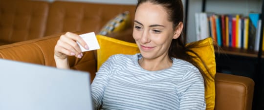 Happy woman shopping on couch