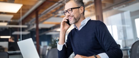 Man on phone confirming shipment details using UPS software