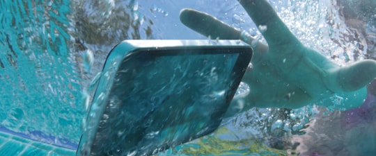 Woman dropping smartphone in pool 