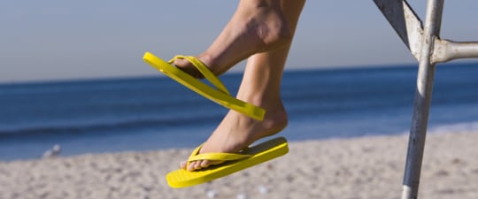 Woman in flip-flops on the beach