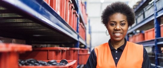 Female warehouse worker in orange vest