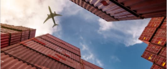 Plane flying over shipping containers