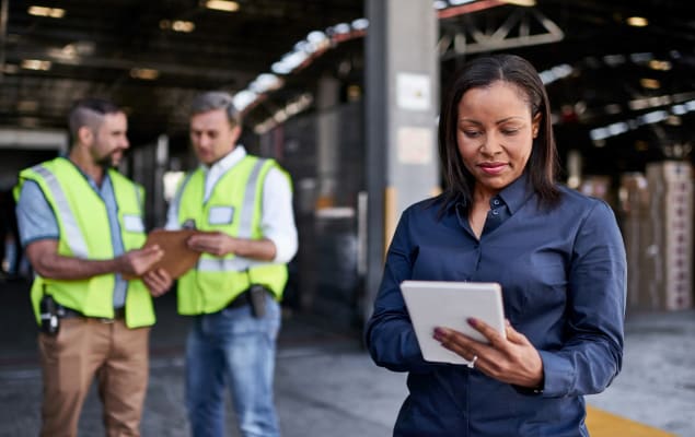 Woman in warehouse checking the status of inbound shipments