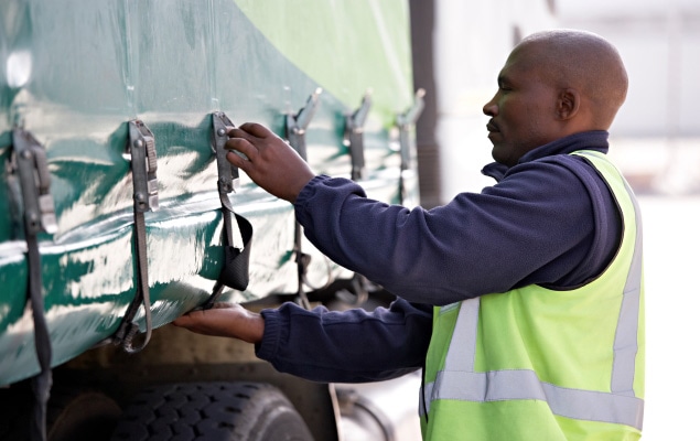 Worker securing freight shipment on trailer