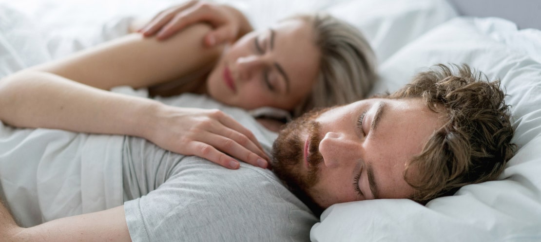 Couple asleep in bed